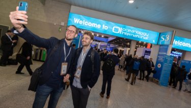 Oi blog image of two attendees taking a selfie at Oceanology International event entrance